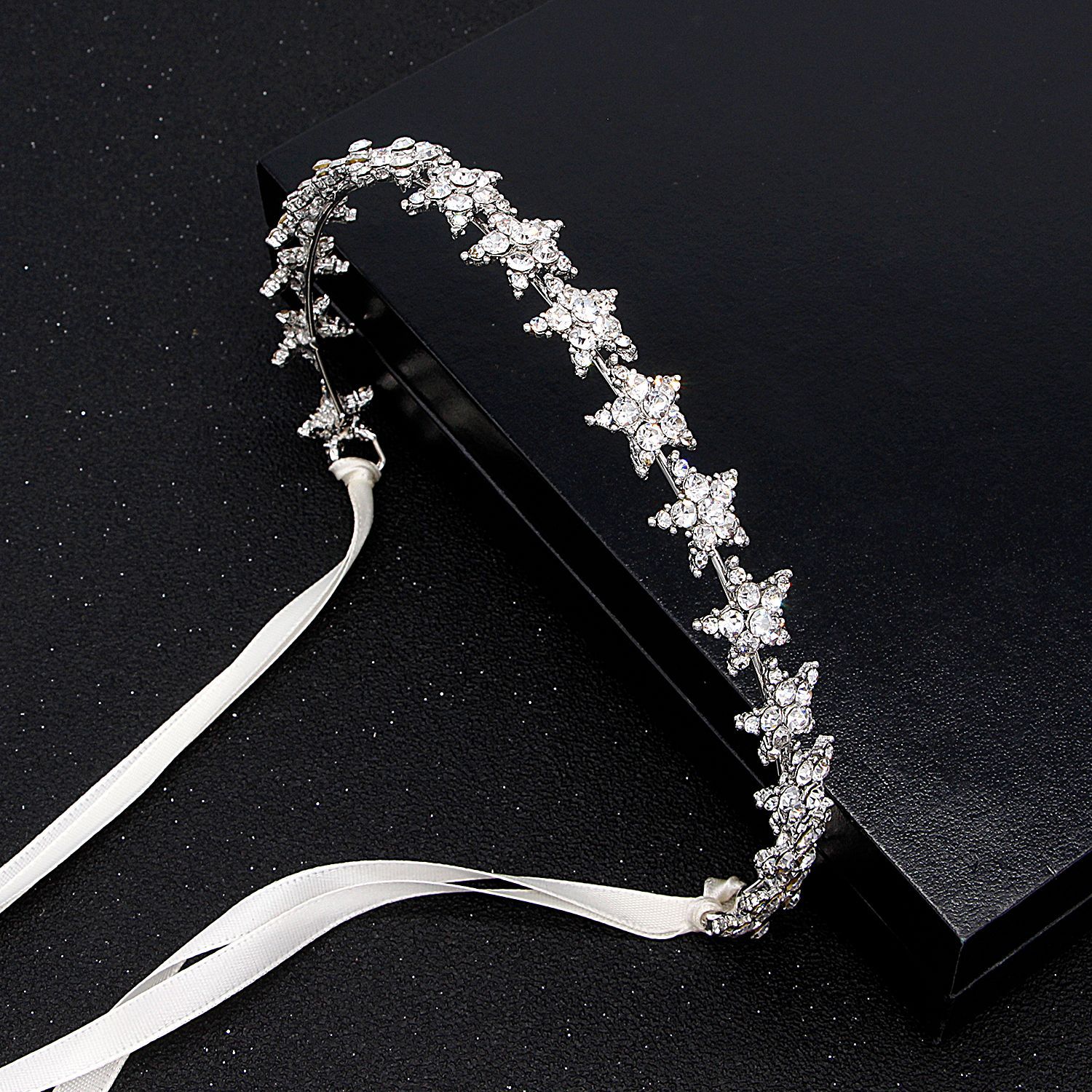 Silver tiara with decorative elements on a black background